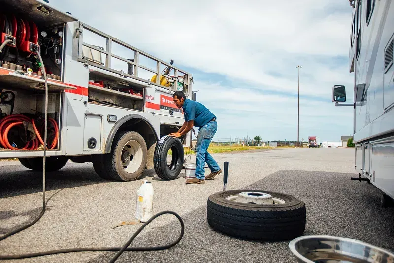 Technician helping stuck motorhome with a tire problem